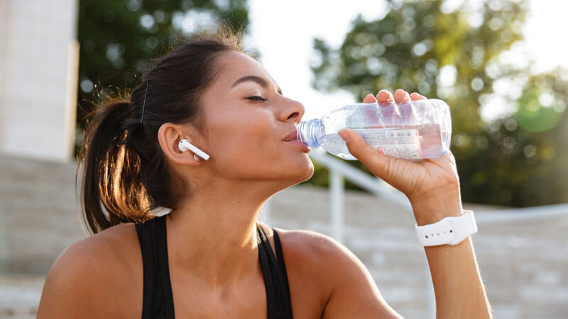 Mujer bebiendo agua para hidratarse