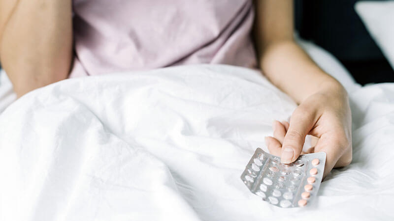 Mujer tomando píldoras anticonceptivas